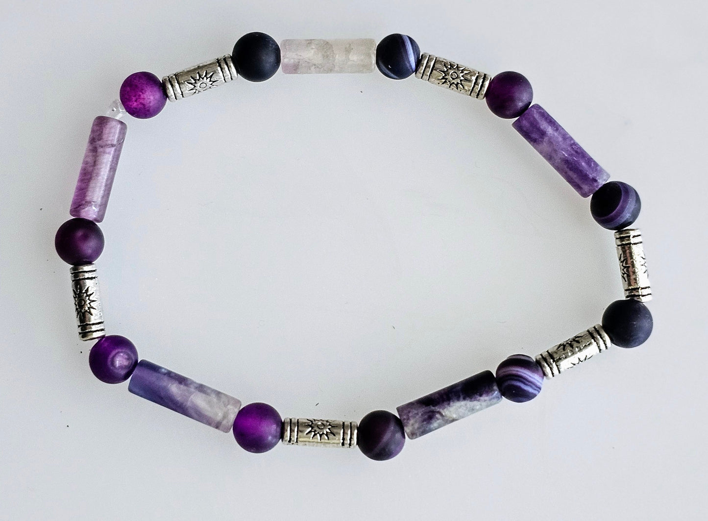 Bracelet with purple and silver spacer beads, and multicolored round beads.