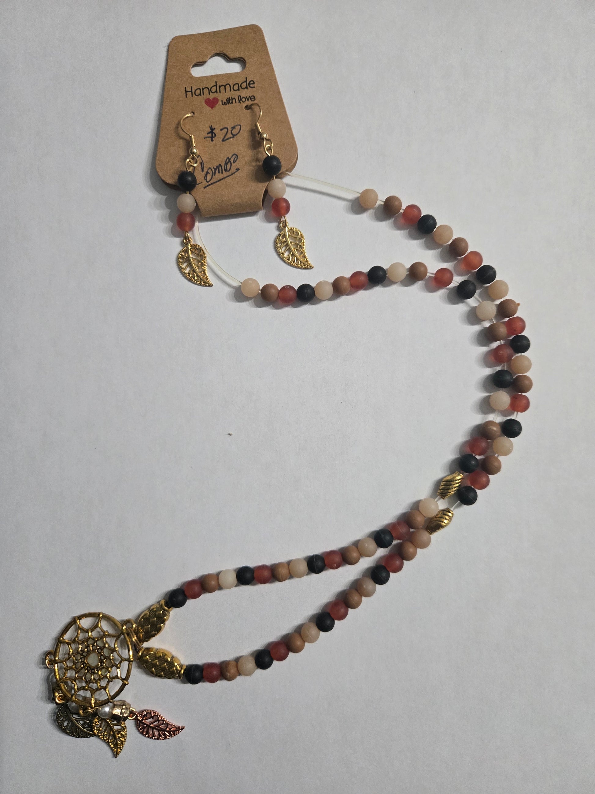 Necklace with multicolored beads and a gold in color dreamcatcher pendant accented with multicolored leaf charms + matching earrings.