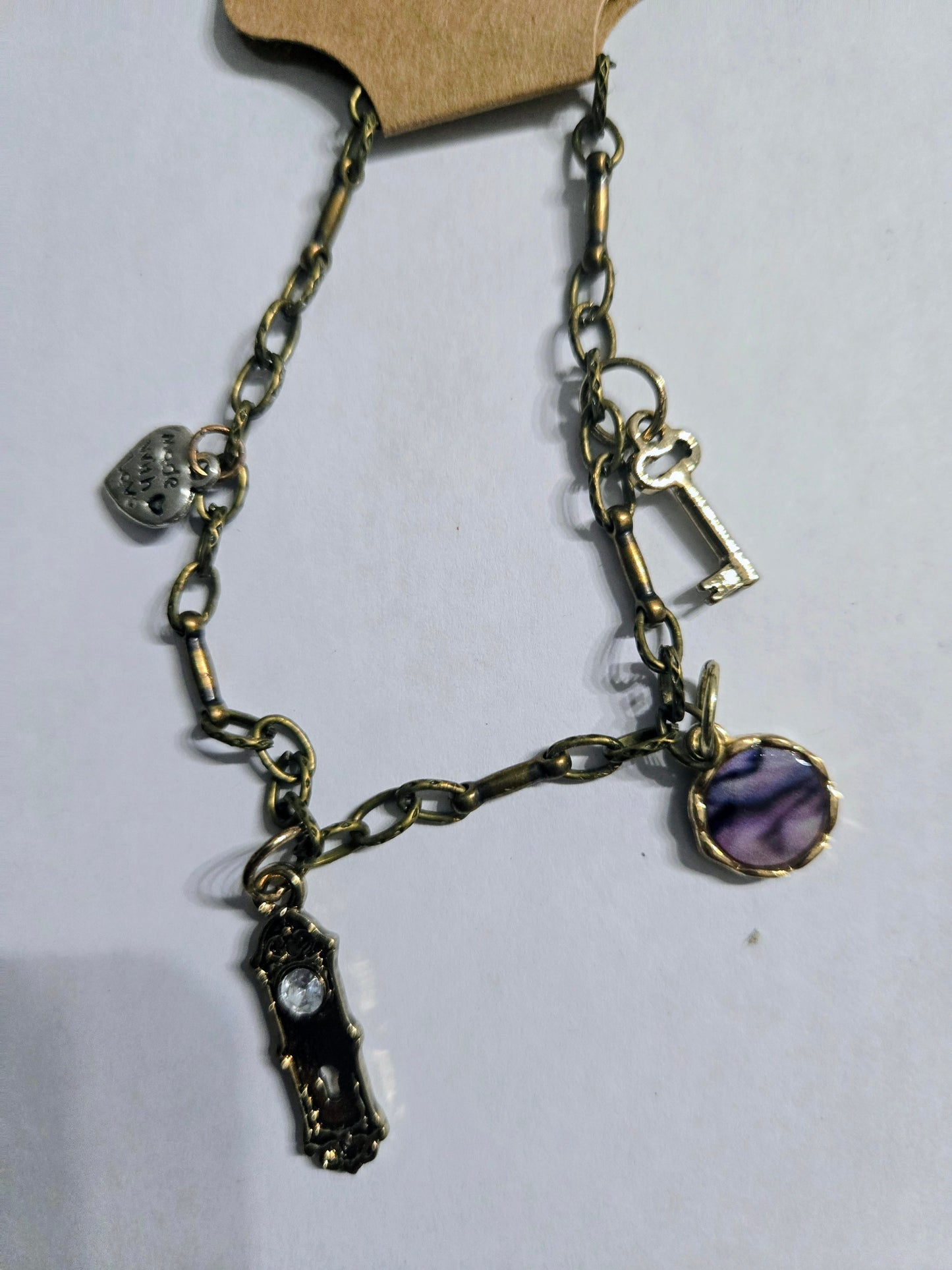 Gold in color chain bracelet with spacer beads, and accented with assorted chams.