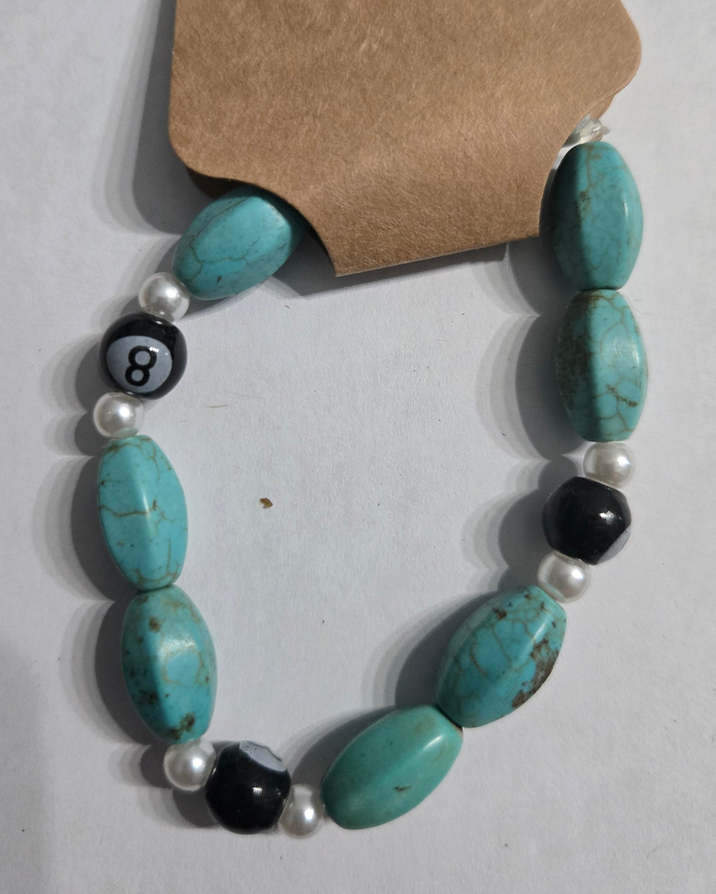 Bracelet with turquoise beads, black eight-ball beads, and white faux pearls.