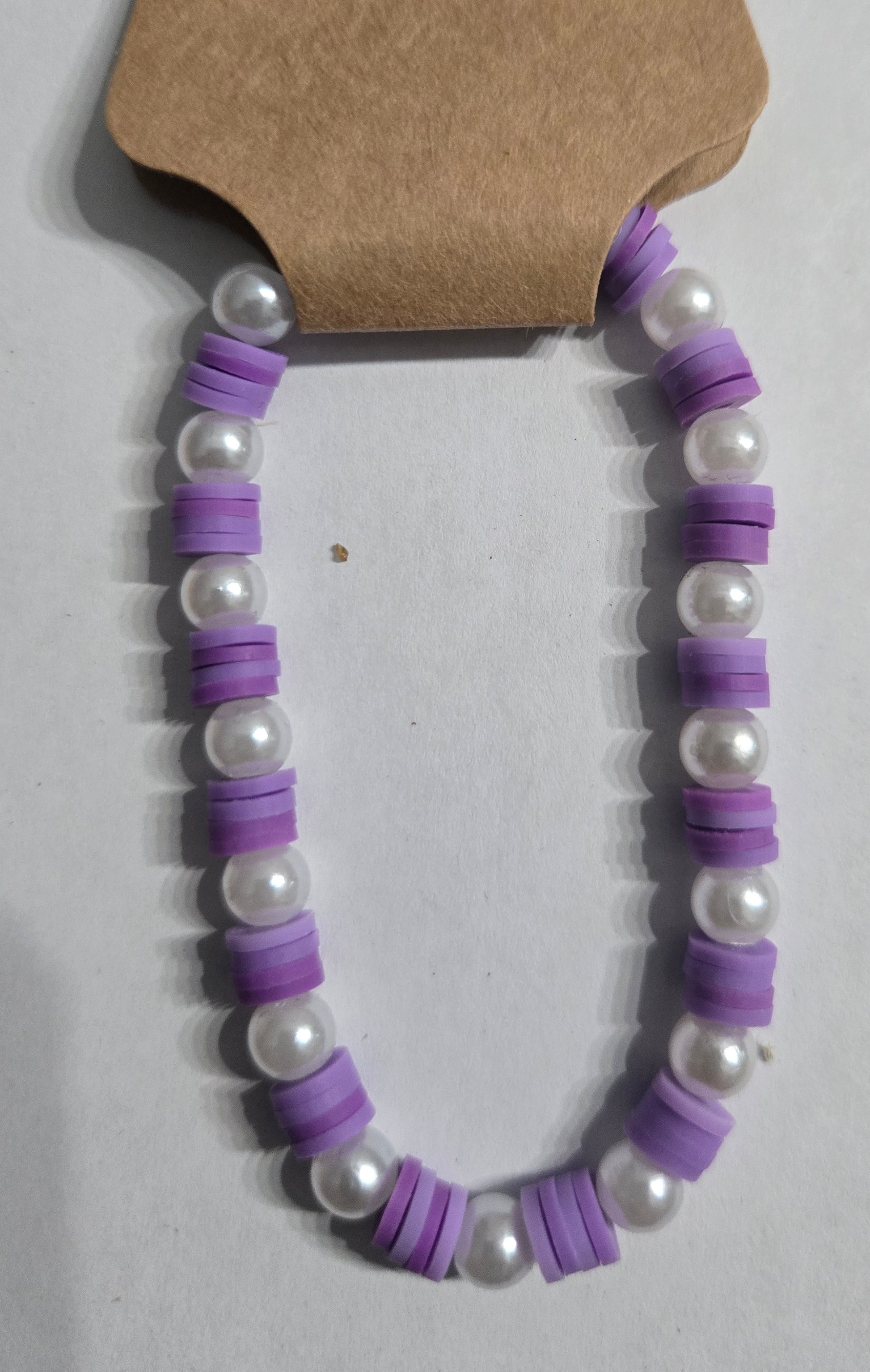 Necklace with purple disk beads and faux pearl beads.
