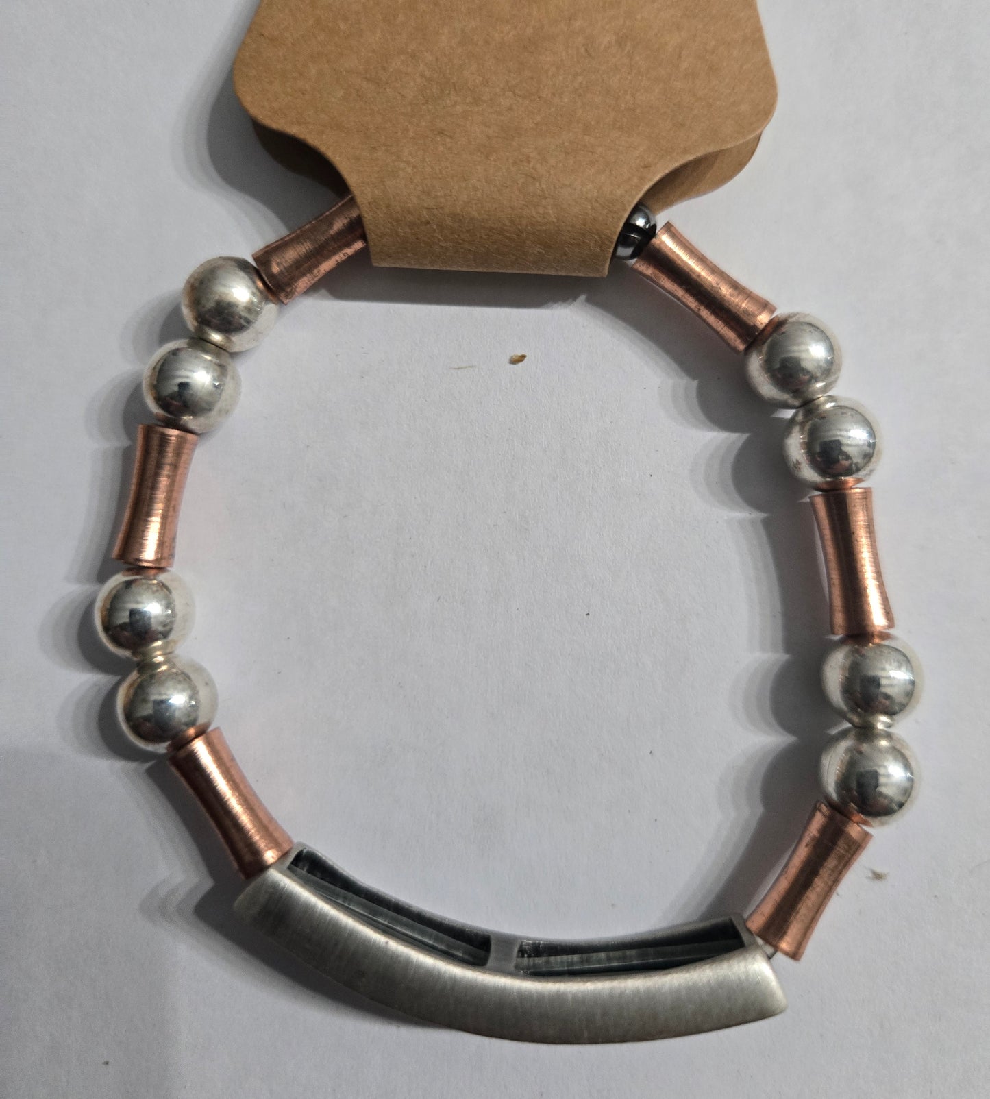 Bracelet with silver in color round beads, accented with copper spacer beads and a large text charm bearing the word "LOVE".