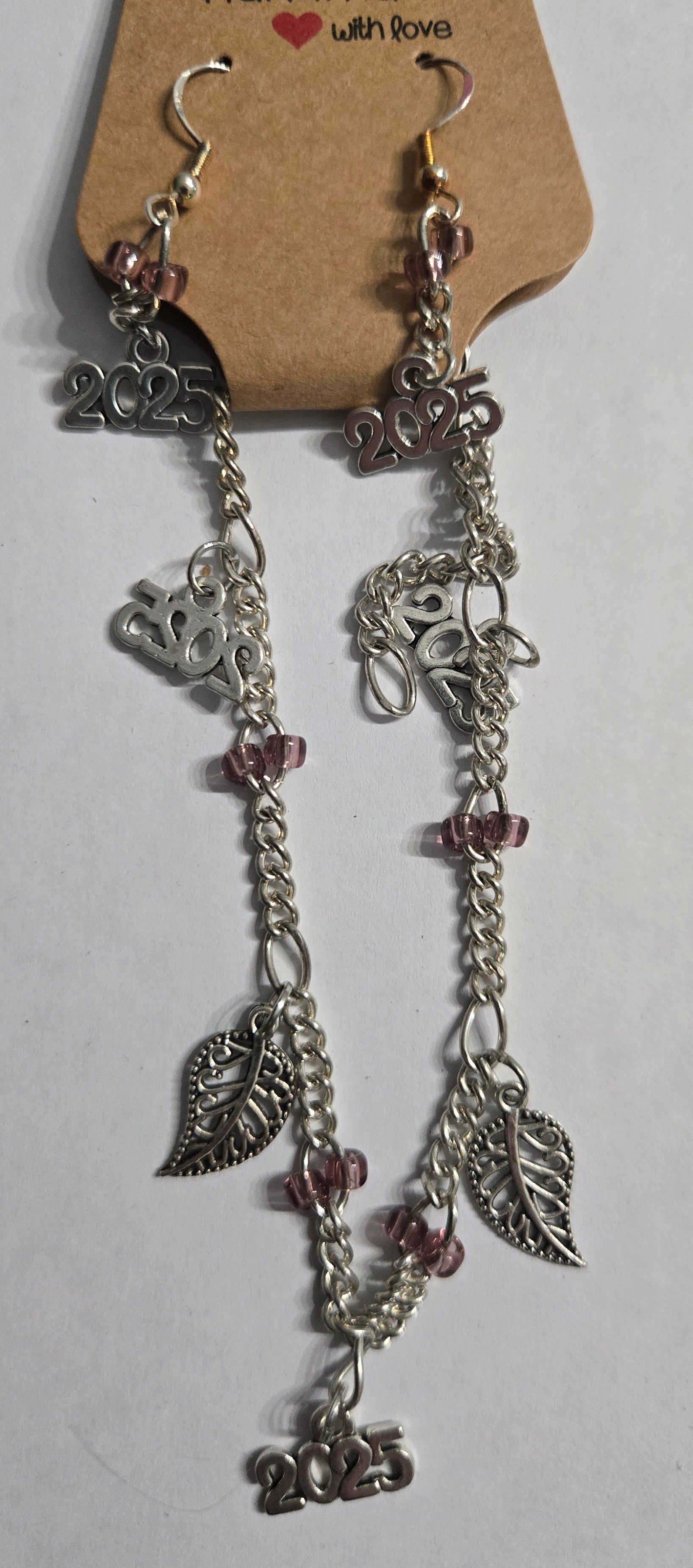 Silver chain bracelet with silver in color "leaf" and "2025" charms + matching earrings.
