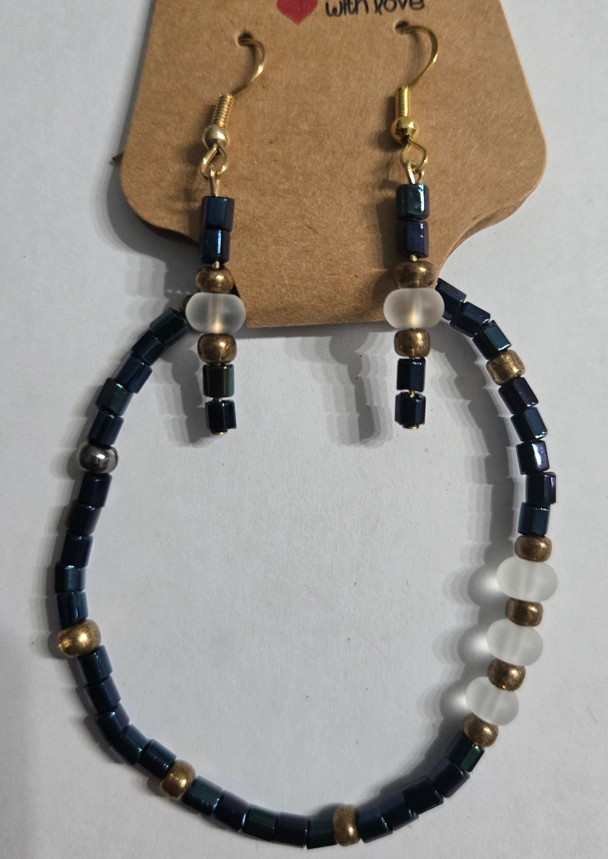 Bracelet crafted with blue glass beads, accented with round frosted and gold in color beads + matching earrings