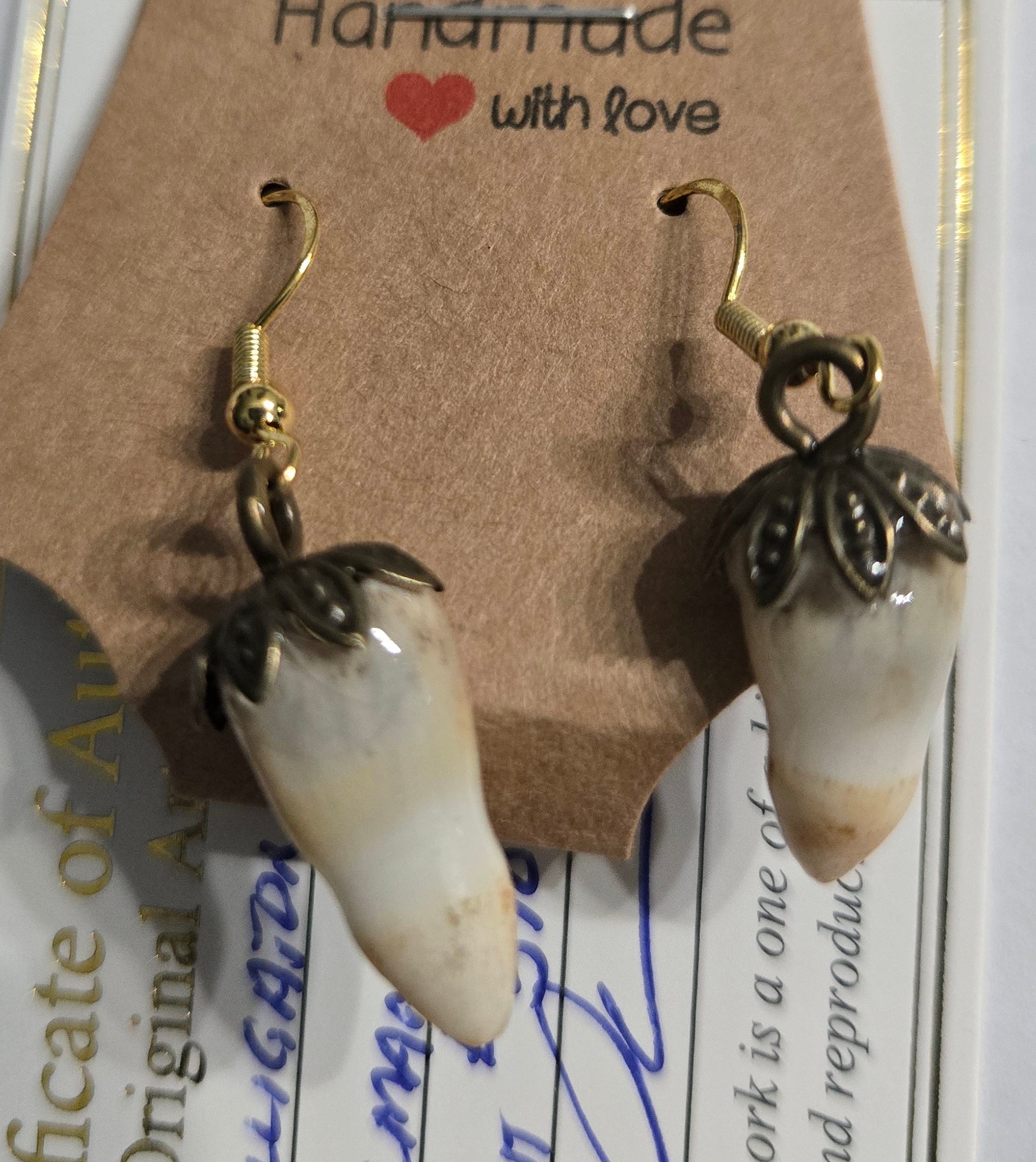 Genuine Alligator Teeth earrings on gold in color earring facets, with pewter floral caps.