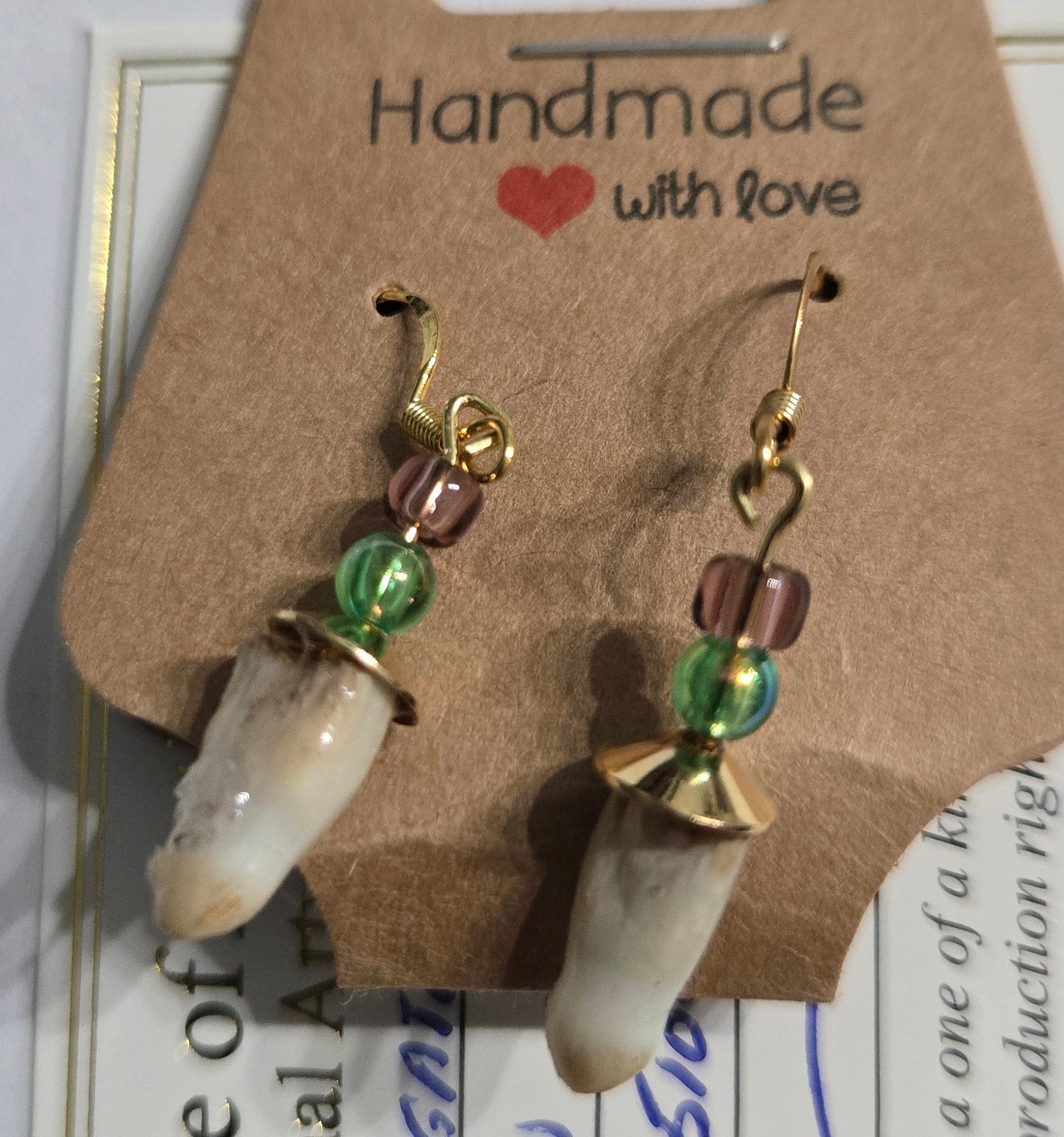 Genuine Alligator Teeth earrings on gold-plated earring facets, with green and purple glass bead accents