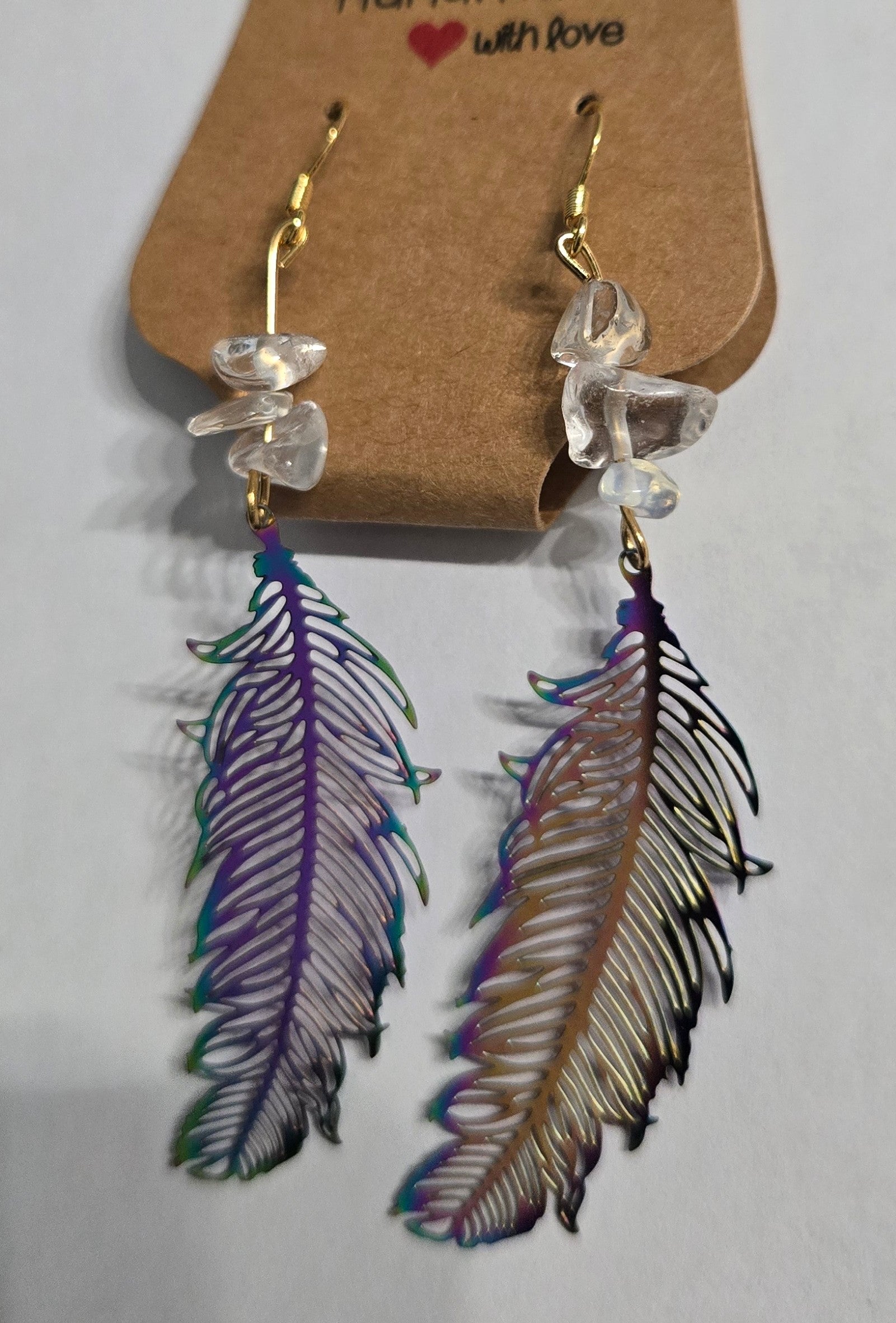 Gold plated earrings with holographic metallic feather charms.
