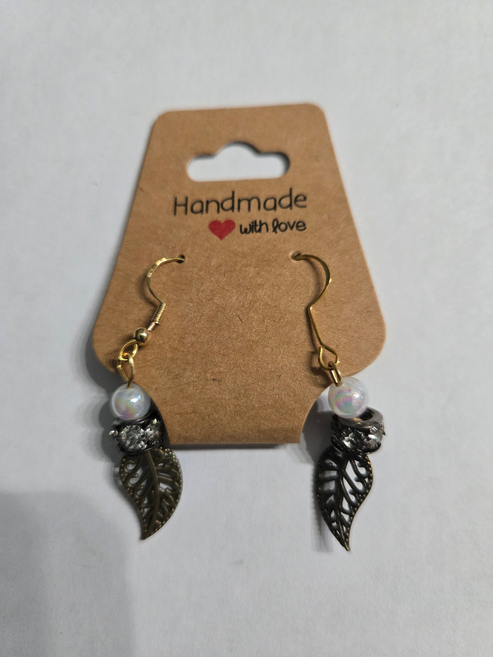 Gold plated earrings with faux pearl beads and pewter leaf charms.