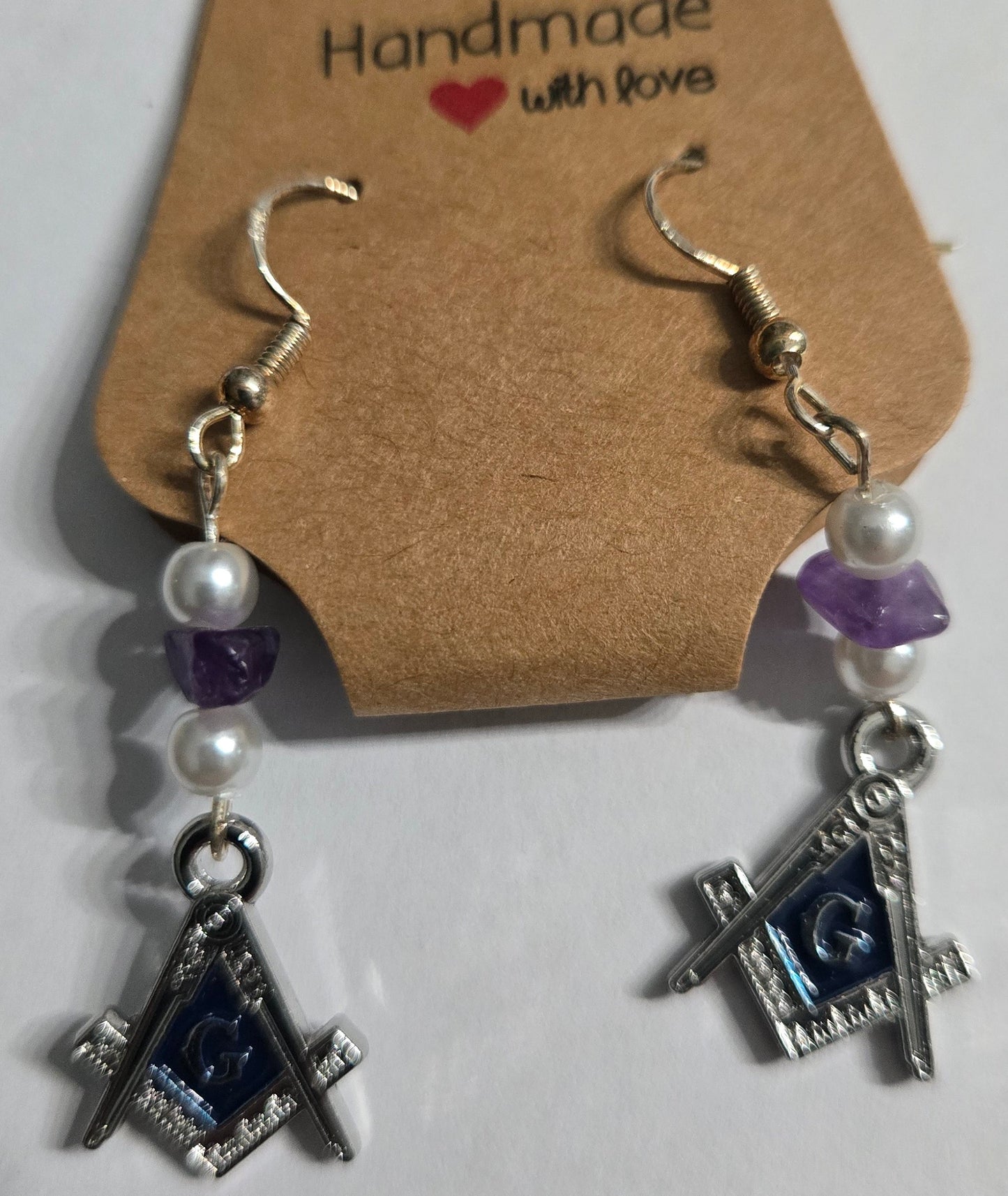 Sterling silver earrings with Masonic charms, accented with faux pearl and purple stone beads.