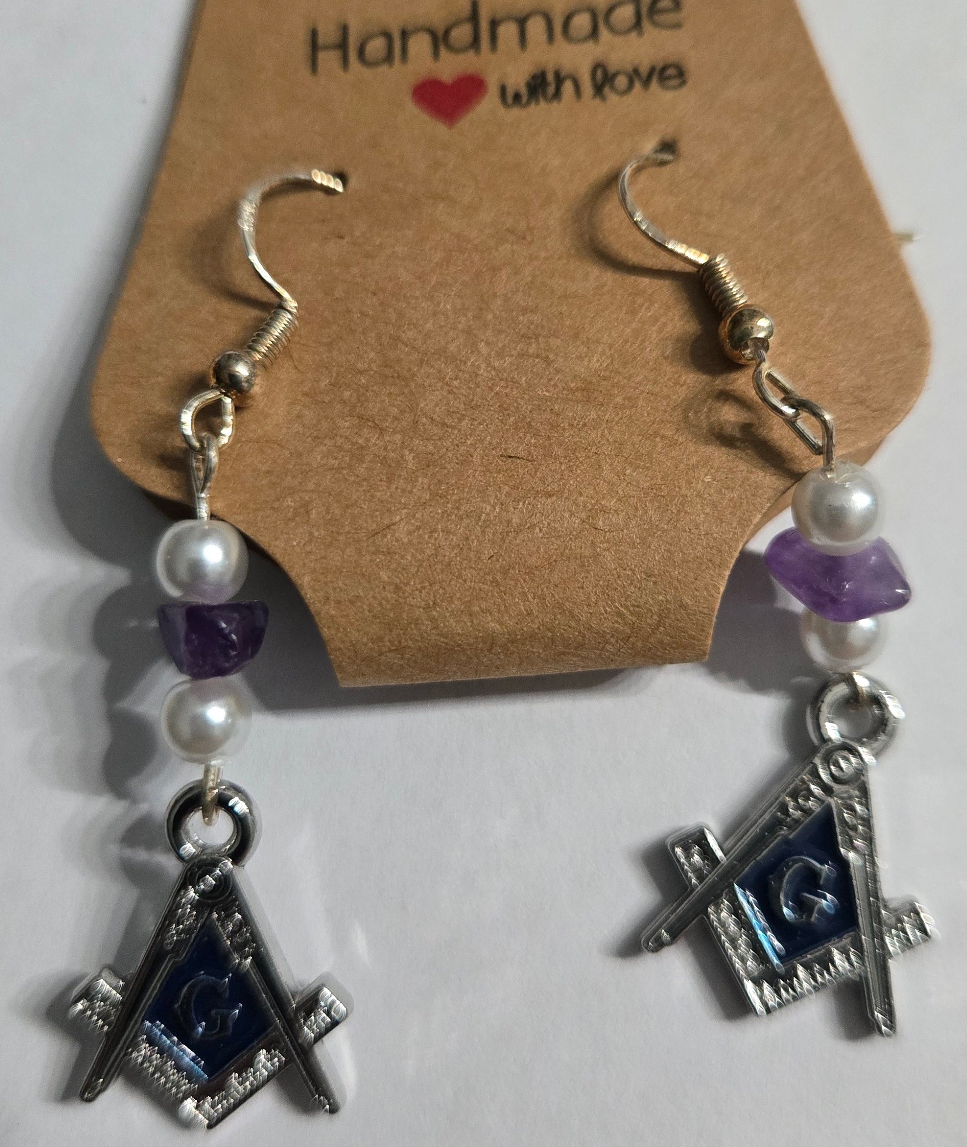 Sterling silver earrings with Masonic charms, accented with faux pearl and purple stone beads.