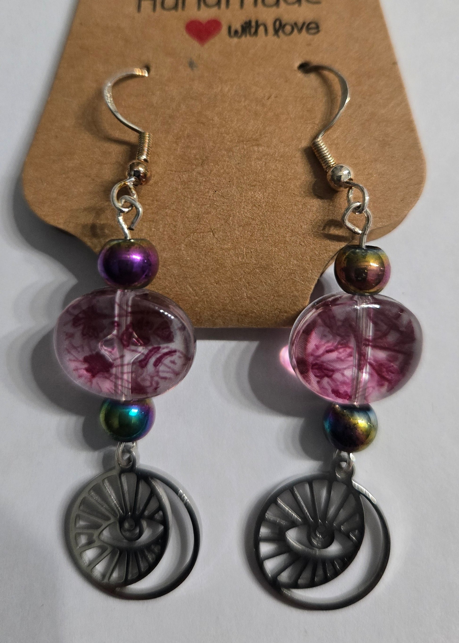 Handmade earrings with pewter "All Seeing Eye" charms, accented with purple / clear glass beads and holographic round beads, and crafted on sterling silver earring facets.