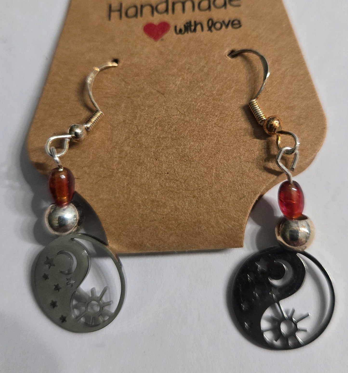 Yin yang earrings with red and silver in color beads.