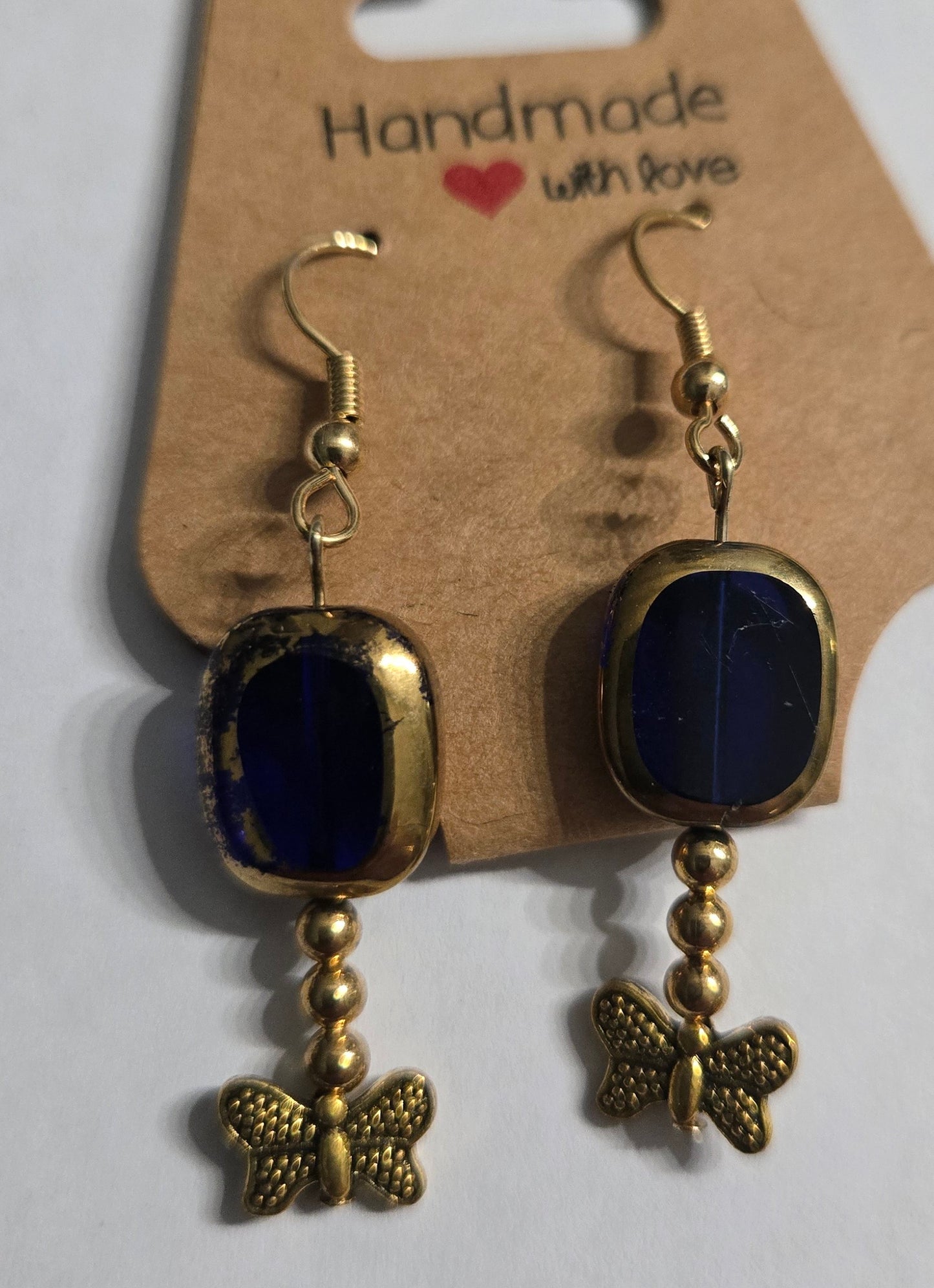 Gold plated earrings with blue glass and gold in color butterfly charms.