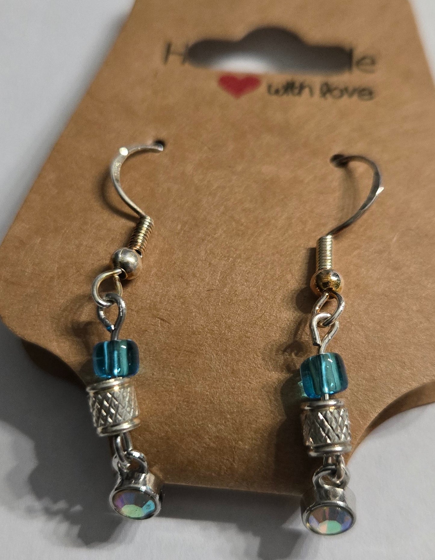 Sterling silver earrings with metallic silver and blue glass beads, accented with a sterling silver pendant encrusted with a CZ simulated diamond.