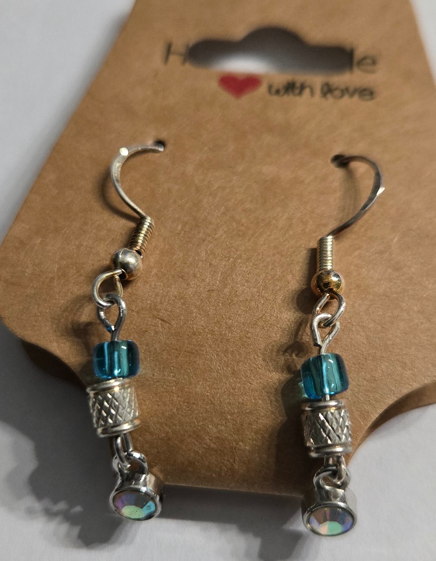 Sterling silver earrings with metallic silver and blue glass beads, accented with a sterling silver pendant encrusted with a CZ simulated diamond.