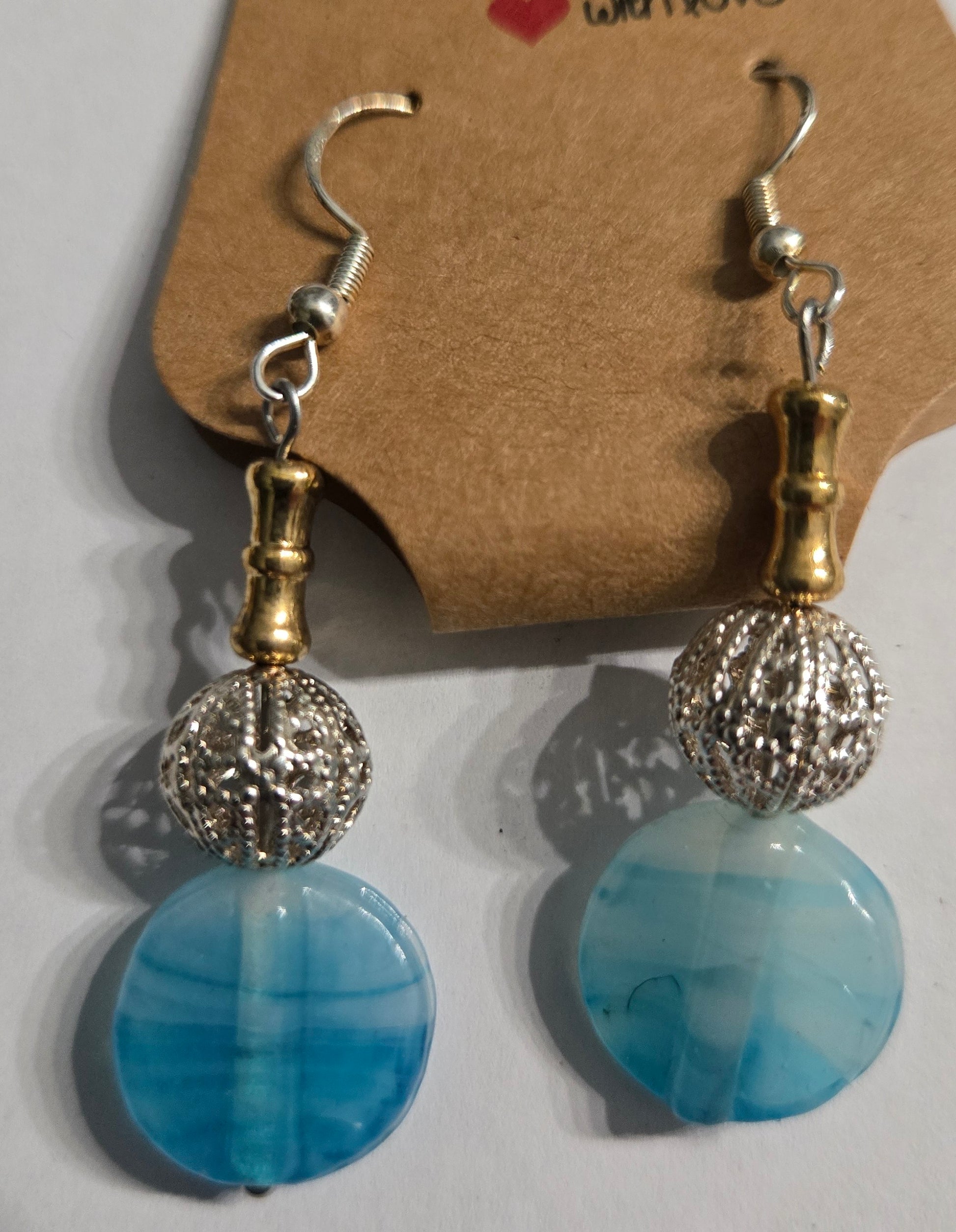 Sterling silver earrings with round blue and silver metallic beads, accented with gold spacer charms.