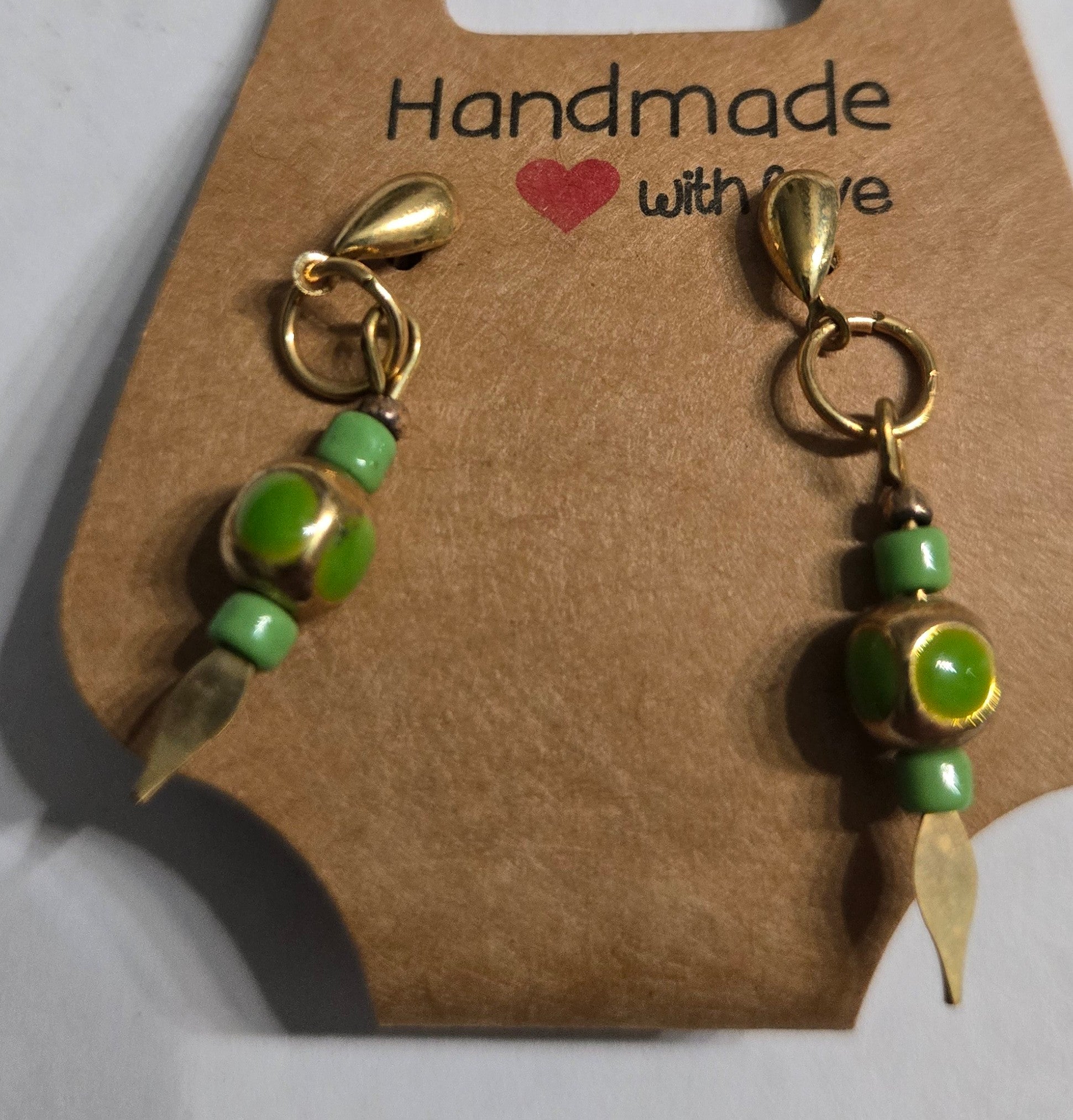 Gold plated earrings with green and gold metallic beads.