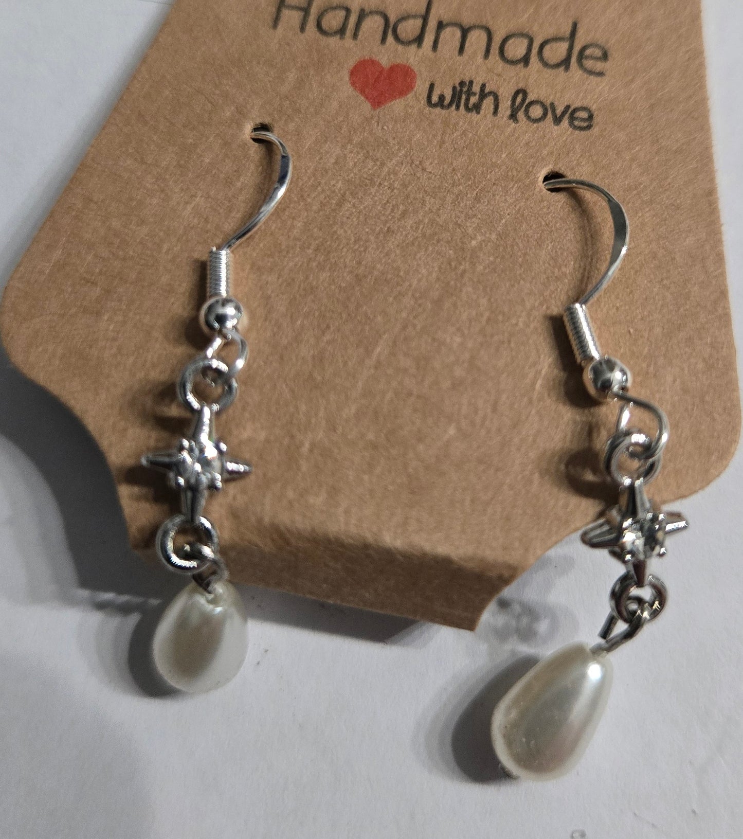 Sterling silver earrings with silver metallic CZ beads, accented with faux pearl charms.
