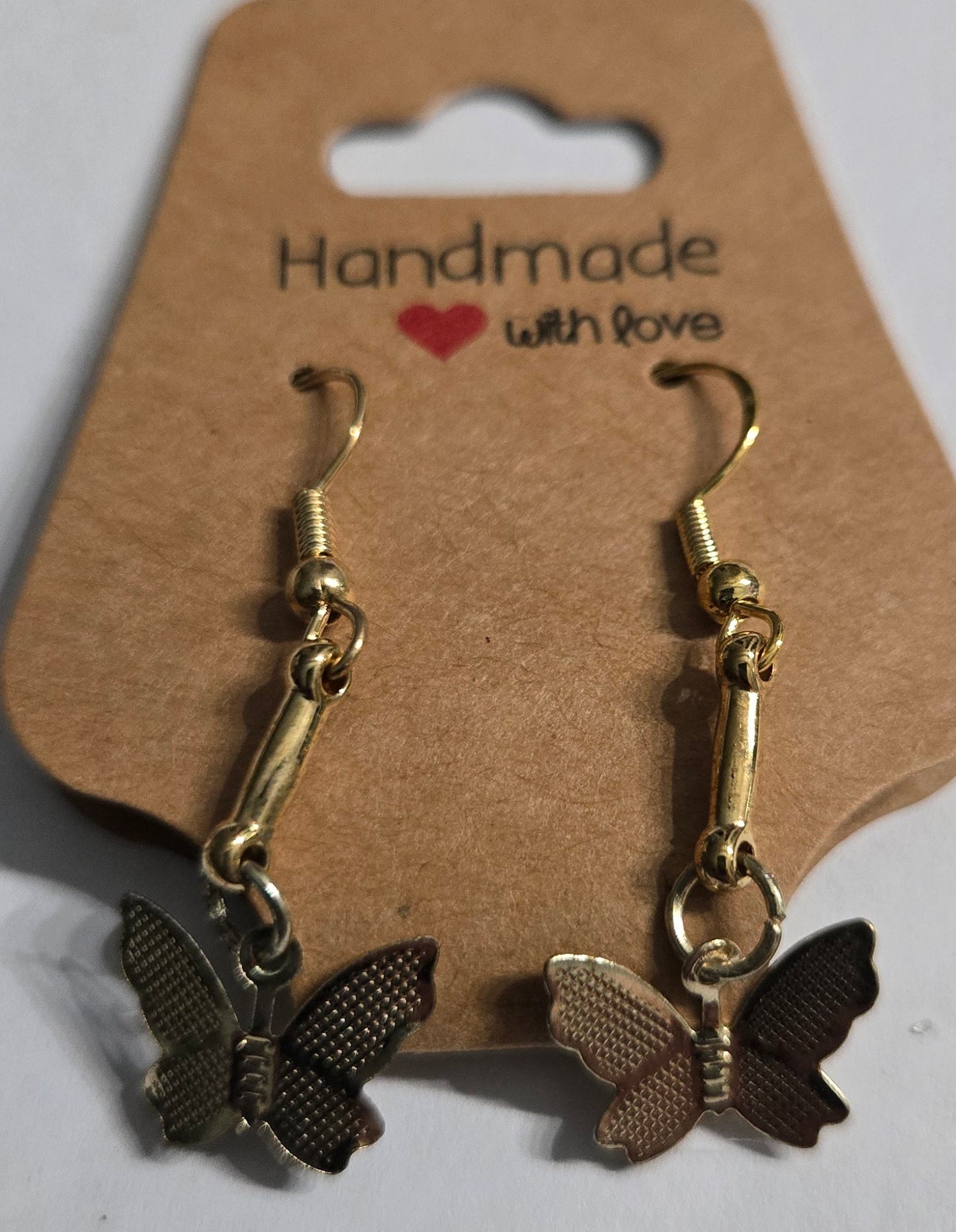 Gold plated earrings with gold metallic spacer beads, accented with gold metallic butterfly charms.