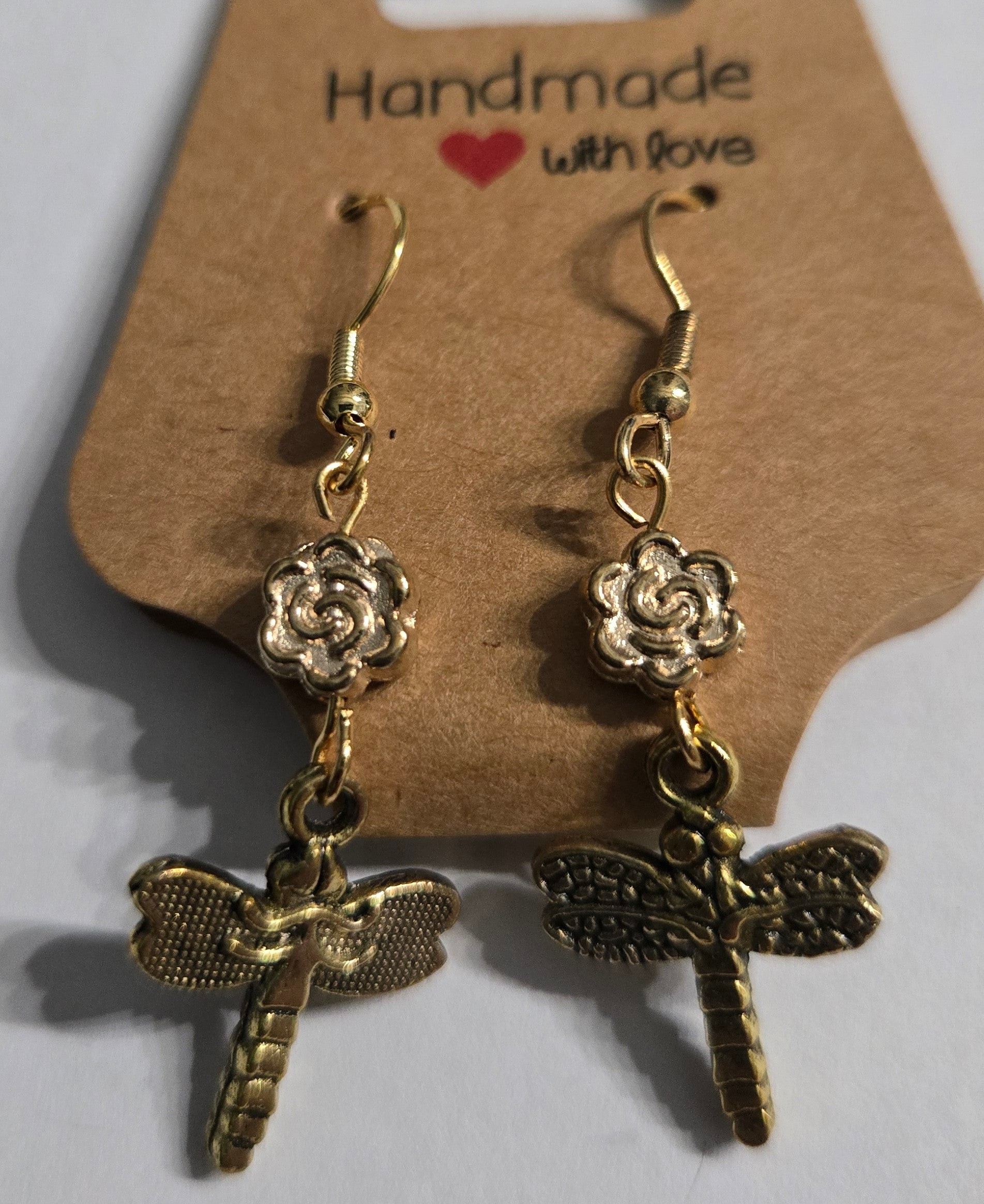 Gold plated earrings with gold metallic flower beads, accented with gold metallic dragonfly charms.