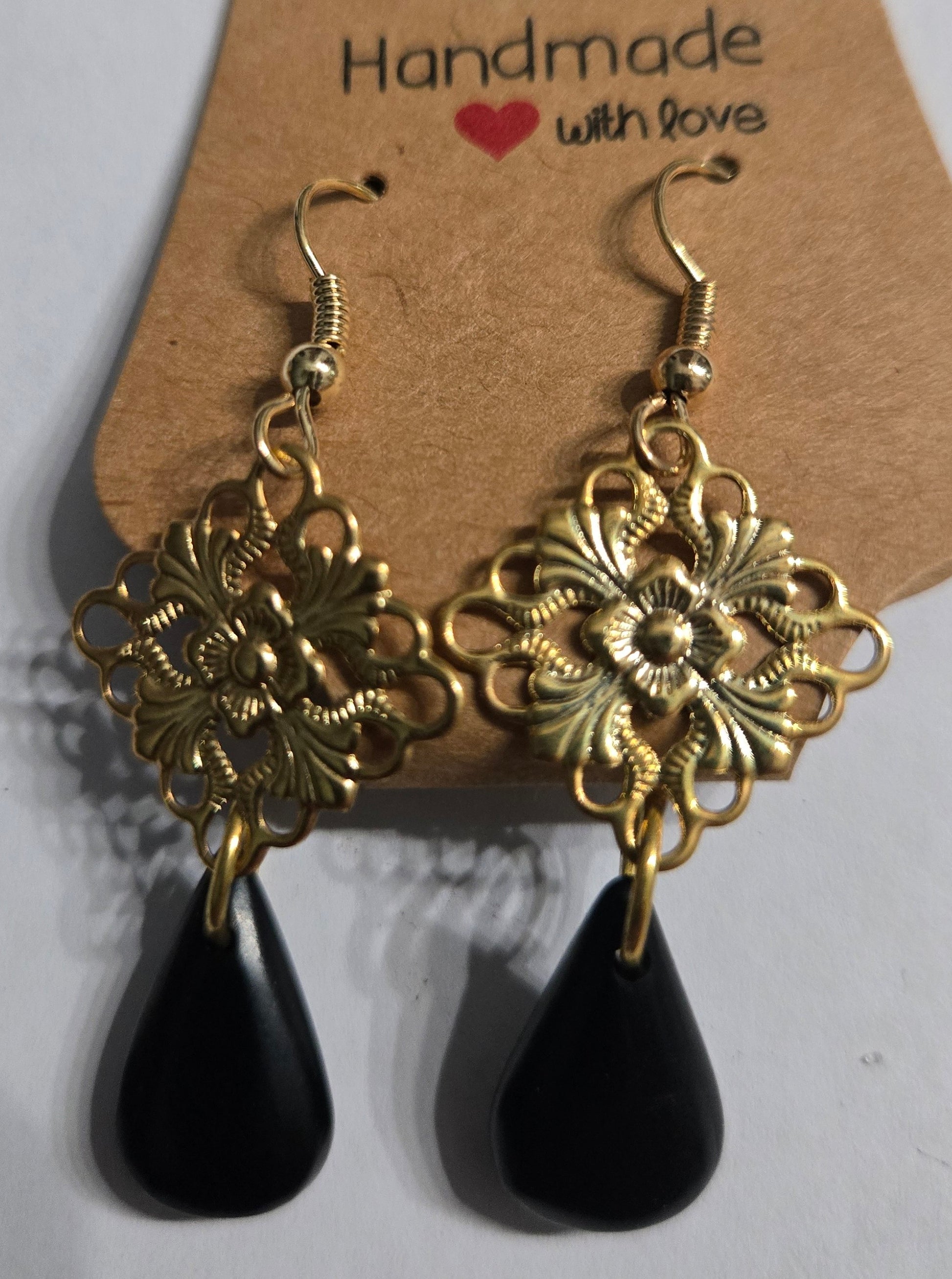 Gold plated earrings with gold metallic beads, accented with faux onyx teardrop charms.