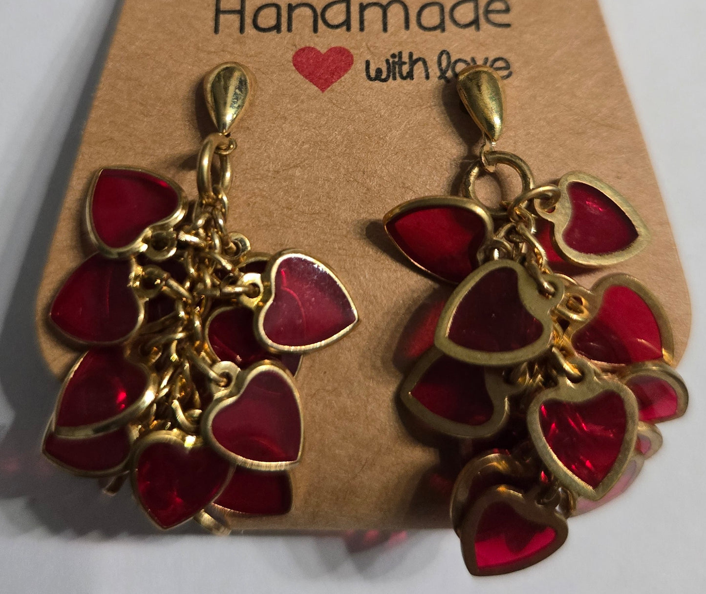 Gold plated earrings with gold metallic red glass inlay heart charms.