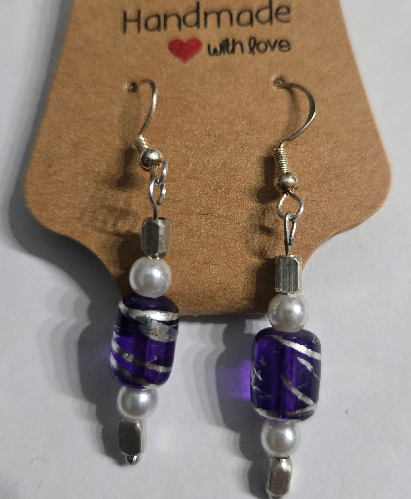Sterling silver earrings with faux pearl and metallic silver beads, with a purple center charm.