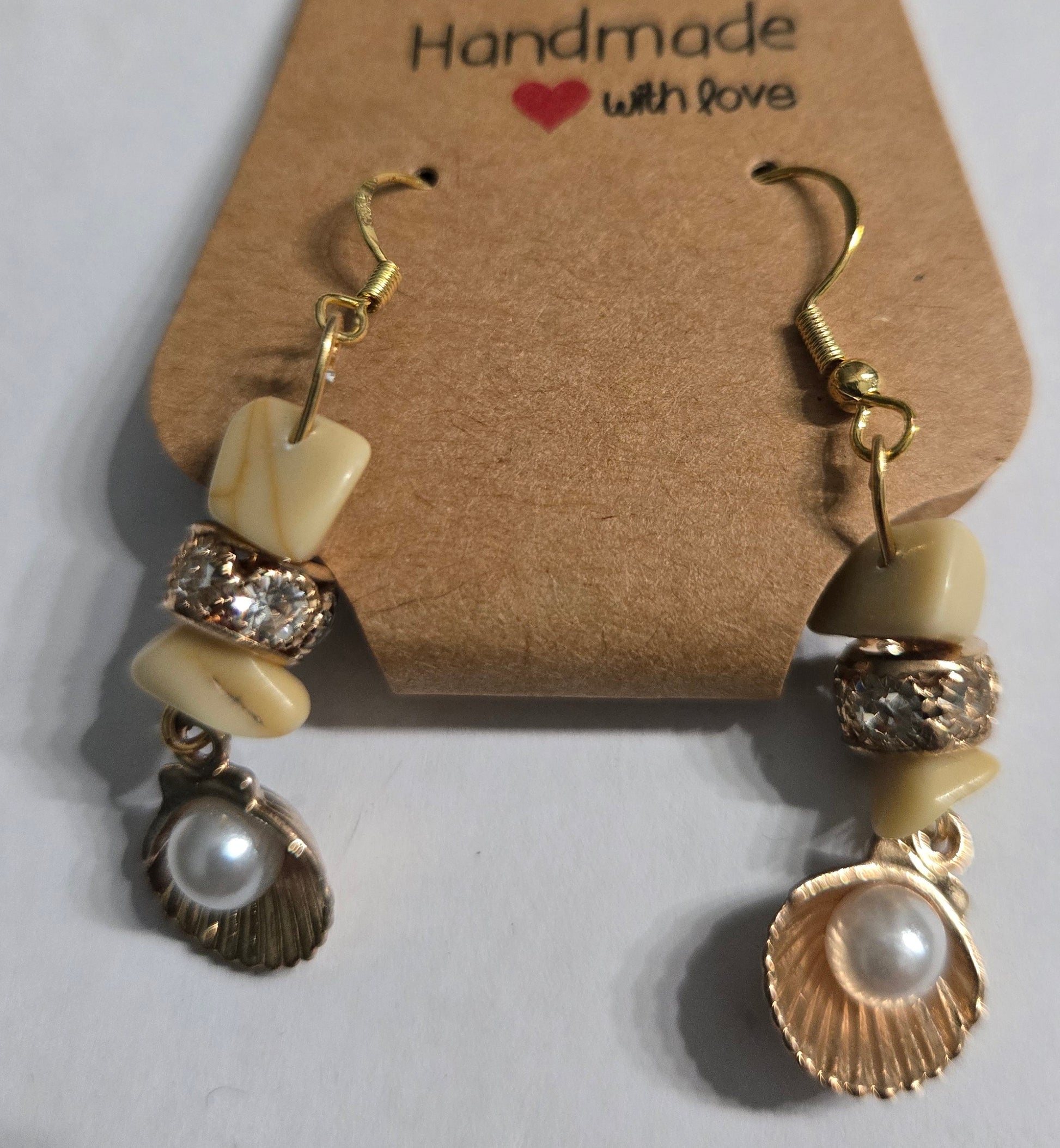 Gold plated earrings with amber stone beads, gold metallic beads with CZ stones, and seashell + faux pearl charms.