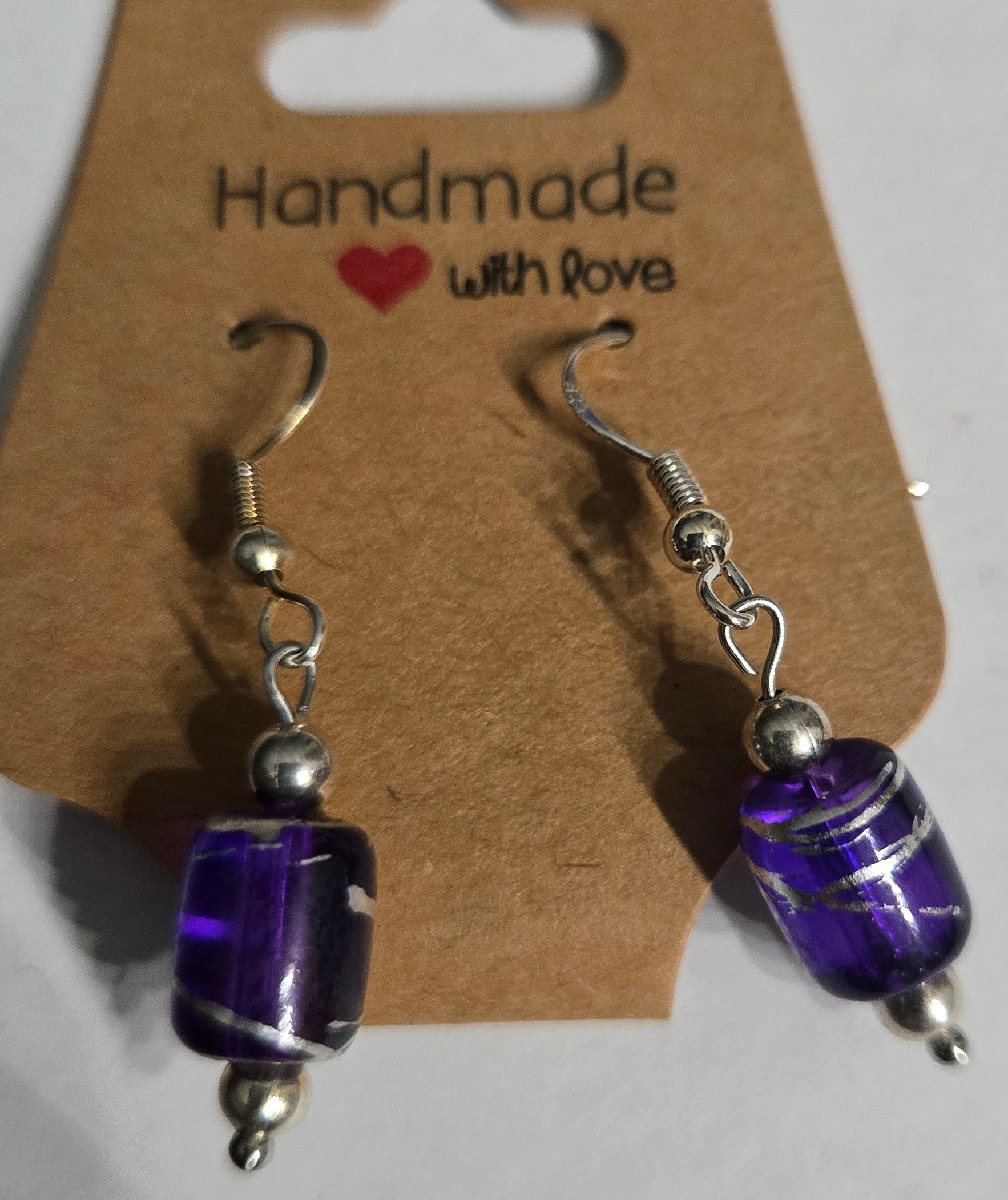 Sterling silver earrings with purple glass charms.
