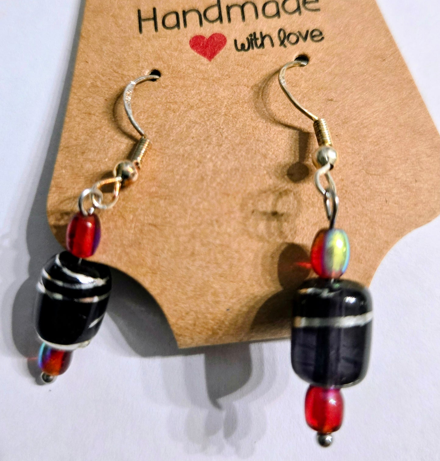 Sterling silver earrings with red glass beads and black glass charms.