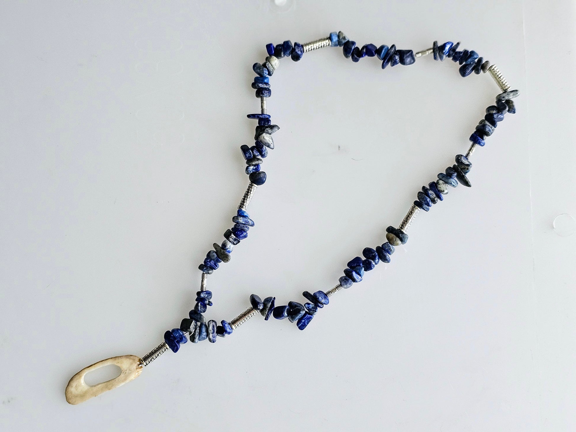 Handmade beaded necklace with Lapis Lazuli blue stones, accented with silver tube charms and a focal charm made from authentic deer antler.