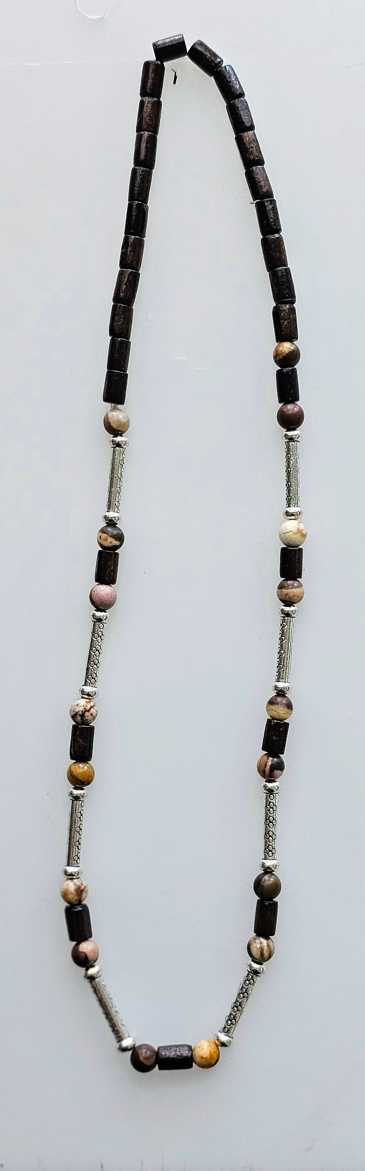 Handmade beaded necklace with brown wooden beads, accented with various charms.