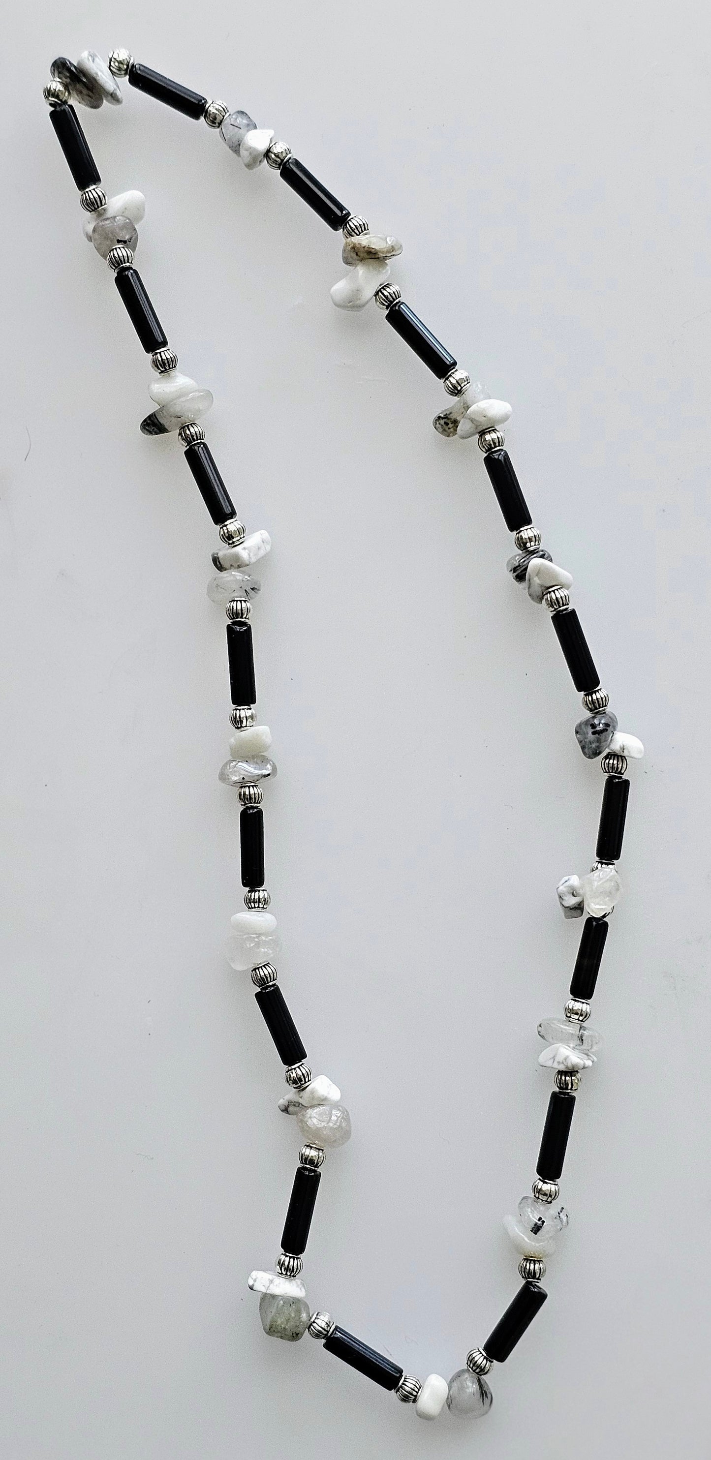 Handmade beaded necklace with black glass tube beads, accented by silver and white beads.
