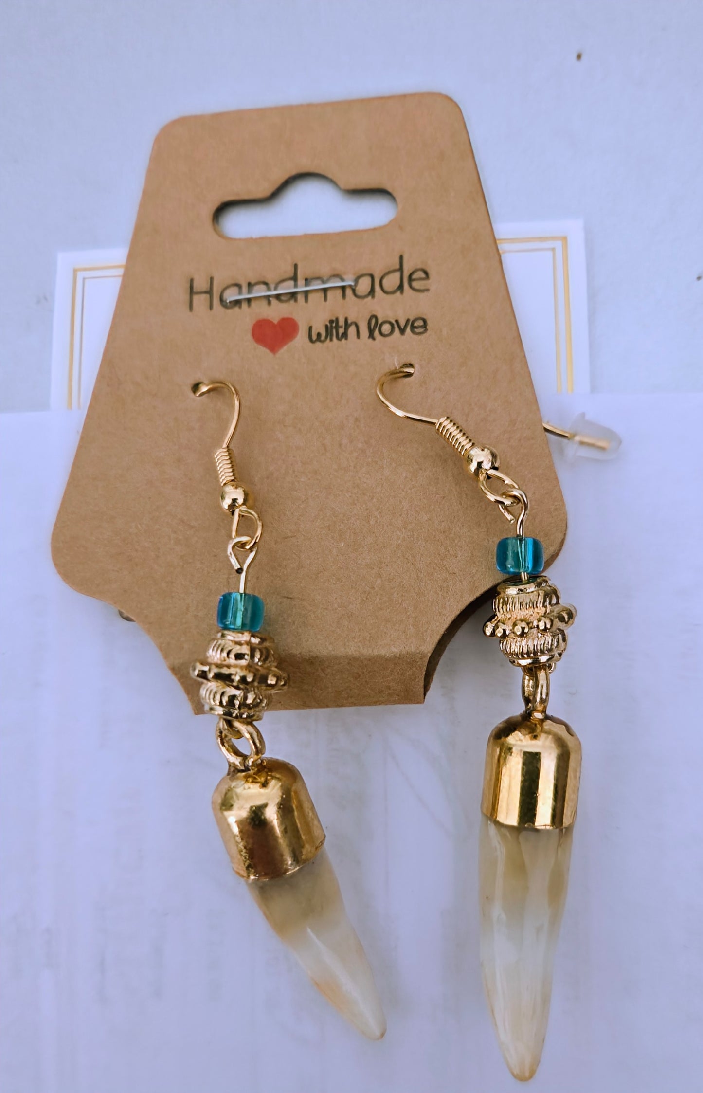Genuine Alligator Teeth earrings mounted on gold-plated earring facets, with green and gold accent beads.